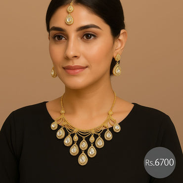 Gold-tone pear-drop kundan bridal necklace set with earrings and maang tikka on model – Destiny.pk
