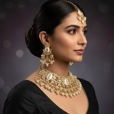 Woman wearing elaborate gold jewelry against a dark background