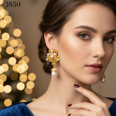 Woman wearing gold earrings with a blurred festive background