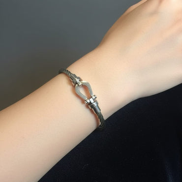 Silver bracelet on a wrist against a dark background