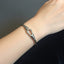 Silver bracelet on a wrist against a dark background