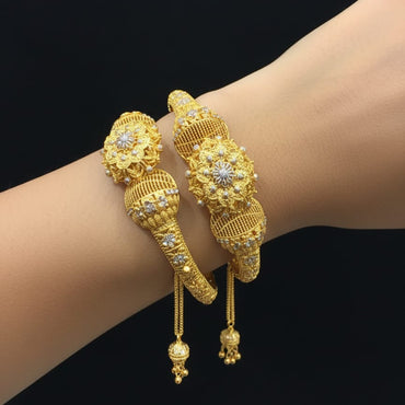 Gold bracelets with intricate designs on a wrist against a black background, featuring the number 8850.