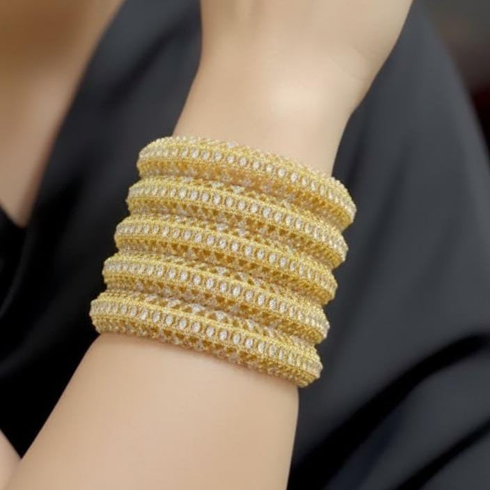 Gold bracelet on a wrist with a blurred background