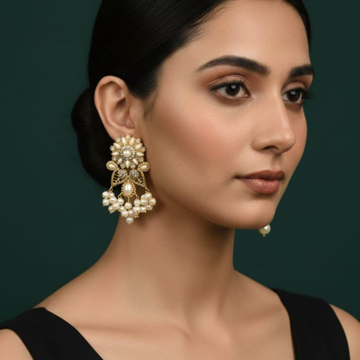 Traditional gold-toned pearl jhumka earrings with intricate design, priced Rs. 1150