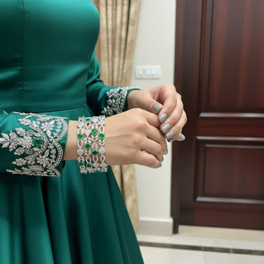 Green dress with intricate arm detailing in a room setting