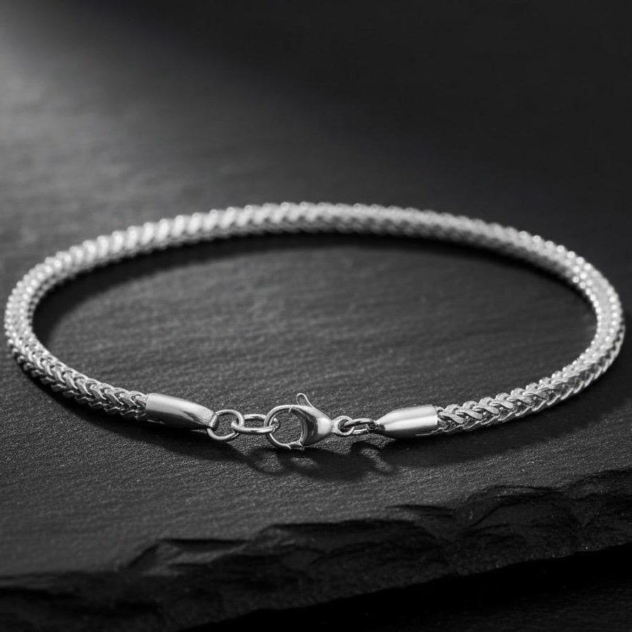 Silver bracelet on a dark stone surface