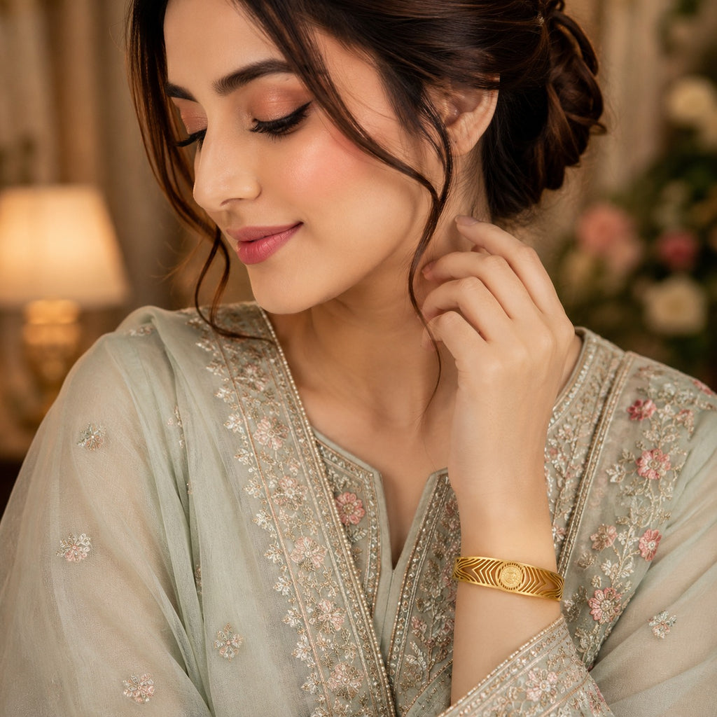 Gold-Tone Engraved Chevron & Medallion Wide Cuff Bangle Bracelet worn by model in Pakistani sage green formal attire