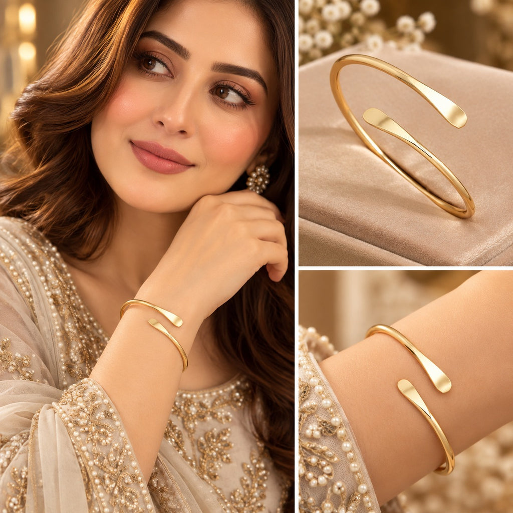 Model wearing a slim gold-tone open cuff bracelet with smooth flattened ends.
