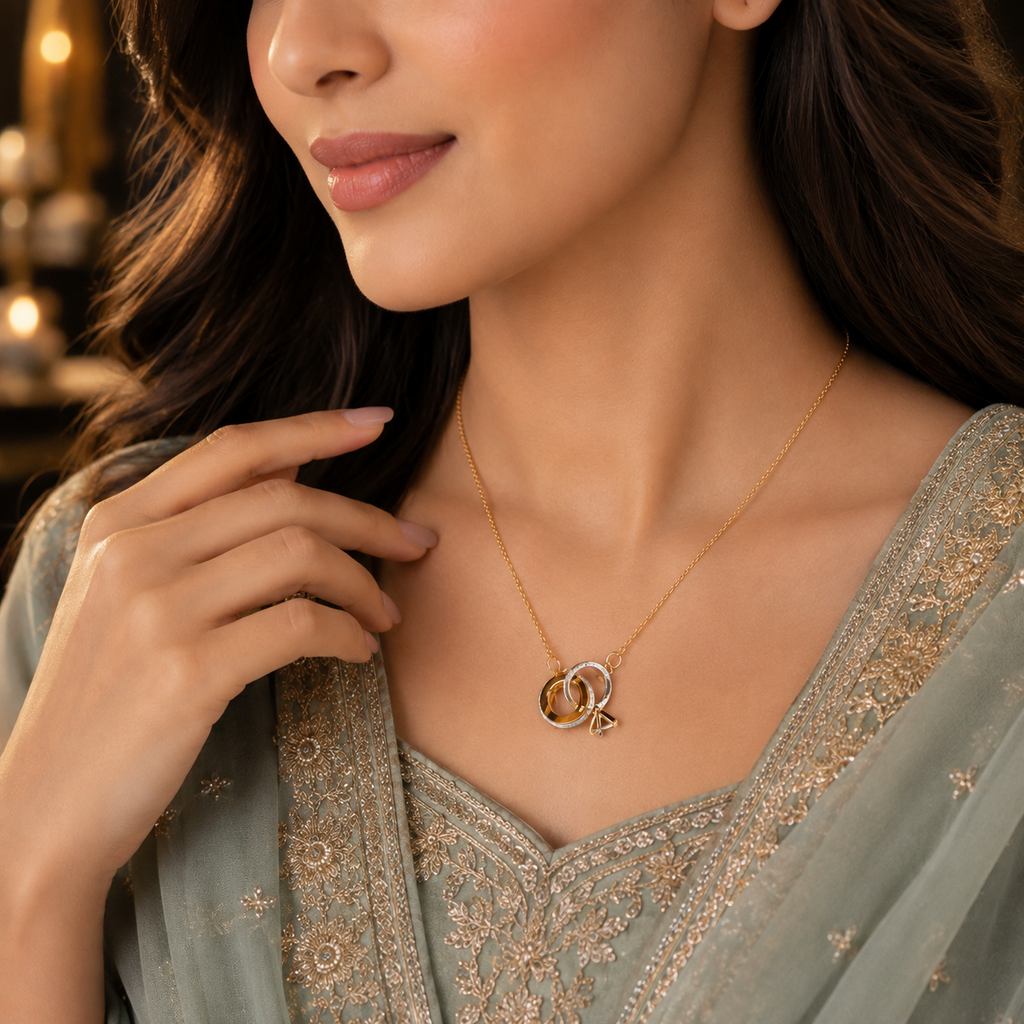 Woman wearing gold-tone interlocking rings CZ pendant necklace with geometric charm drop on a fine cable chain styled with sage green embroidered Pakistani outfit