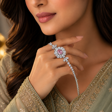 Woman wearing pink CZ oval sunflower halo tennis bracelet with ring connector hand harness in silver-tone styled with a sage green embroidered Pakistani formal outfit