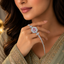 Woman wearing pink CZ oval sunflower halo tennis bracelet with ring connector hand harness in silver-tone styled with a sage green embroidered Pakistani formal outfit