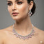 Woman wearing a luxurious diamond necklace and earrings on a gray background