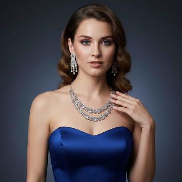 Woman wearing a blue dress and silver jewelry against a dark background