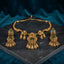 Antique Gold Kundan Temple Pendant Torque Necklace & Jhumka Earrings Bridal Set on dark grey marble surface with teal blue velvet drape backdrop
