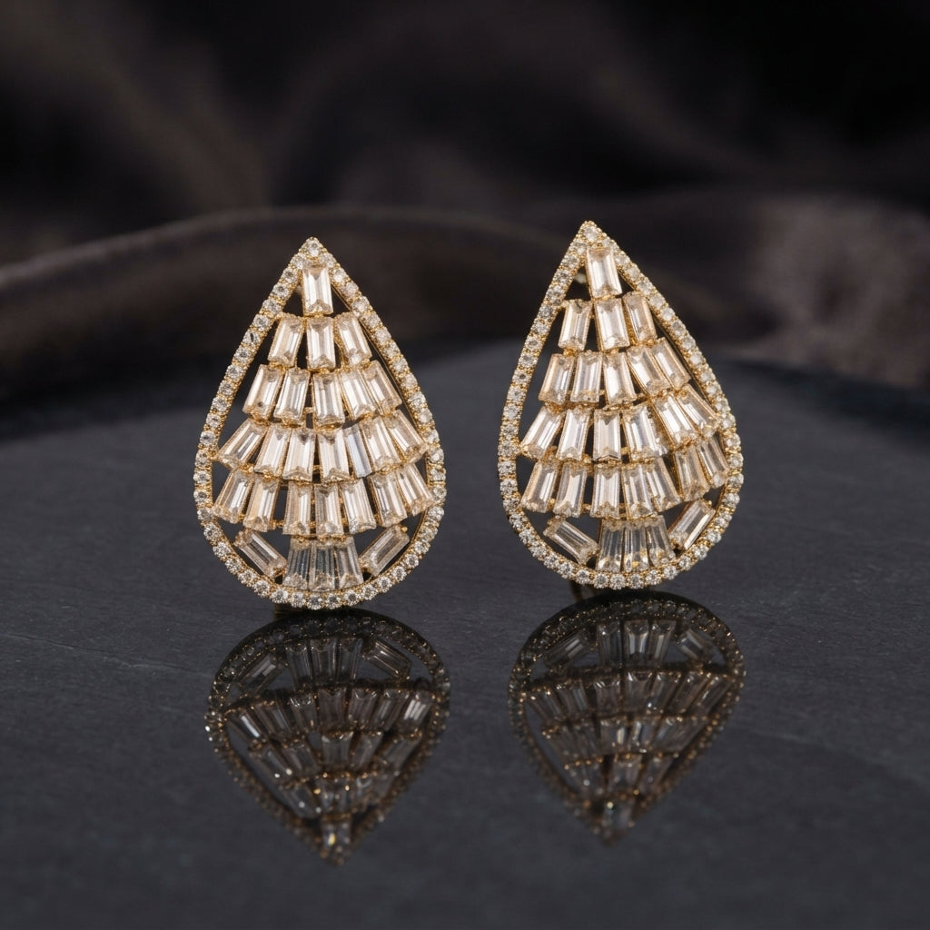 Baguette CZ Teardrop Stud Earrings with Round Pavé Border in silver-tone plating worn on model ear with beige silk curtain backdrop and silver grey blazer showing tiered baguette CZ teardrop with pavé round CZ border
