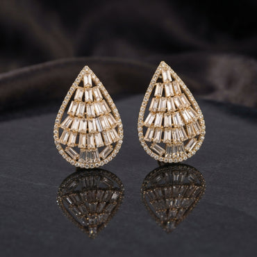Baguette CZ Teardrop Stud Earrings with Round Pavé Border in silver-tone plating worn on model ear with beige silk curtain backdrop and silver grey blazer showing tiered baguette CZ teardrop with pavé round CZ border