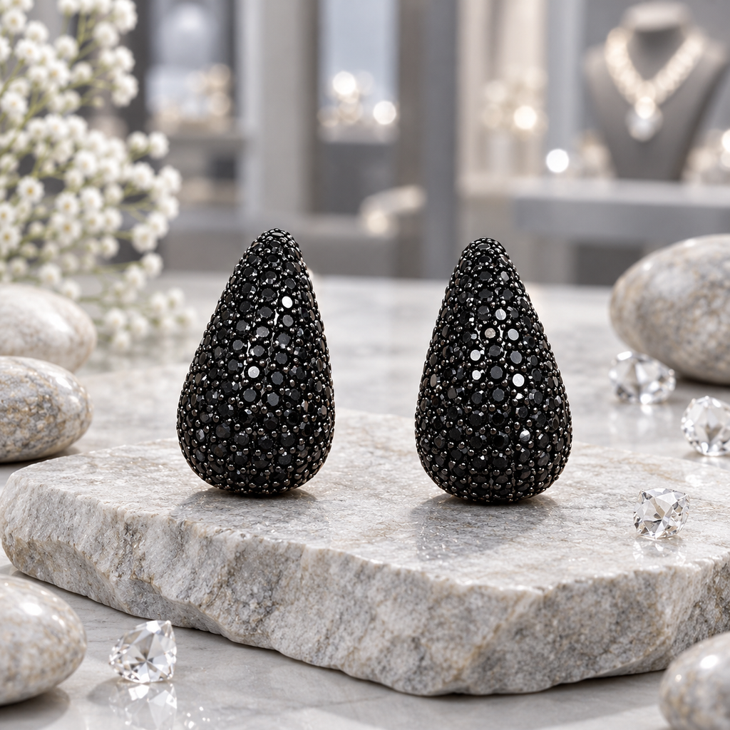 Pair of rounded black teardrop earrings with closely set round black accents, pointed tops and wider curved bases.