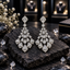 Pair of silver-tone chandelier earrings with cascading clear teardrop accents and sparkling borders.