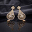 CZ Baguette Fan and Multicolour Sunburst Peacock Drop Earrings in Gold White Diamond on dark mirror surface with charcoal satin backdrop showing 22K gold-tone pair with baguette CZ cone fan open sunburst peacock spoke fan with all-white clear oval CZ accents and white pear CZ halo drop with mirror reflection