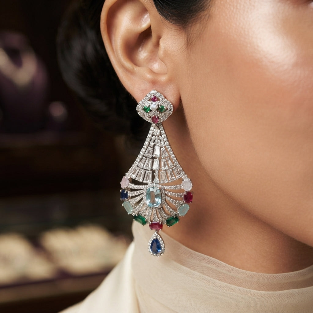 CZ Baguette Fan and Multicolour Sunburst Peacock Drop Earrings in Silver Multicolour on dark slate surface with charcoal satin backdrop showing rhodium silver pair with baguette CZ cone fan open sunburst peacock spoke fan with mint emerald sapphire ruby rose pink oval CZ accents and sapphire blue pear halo drop