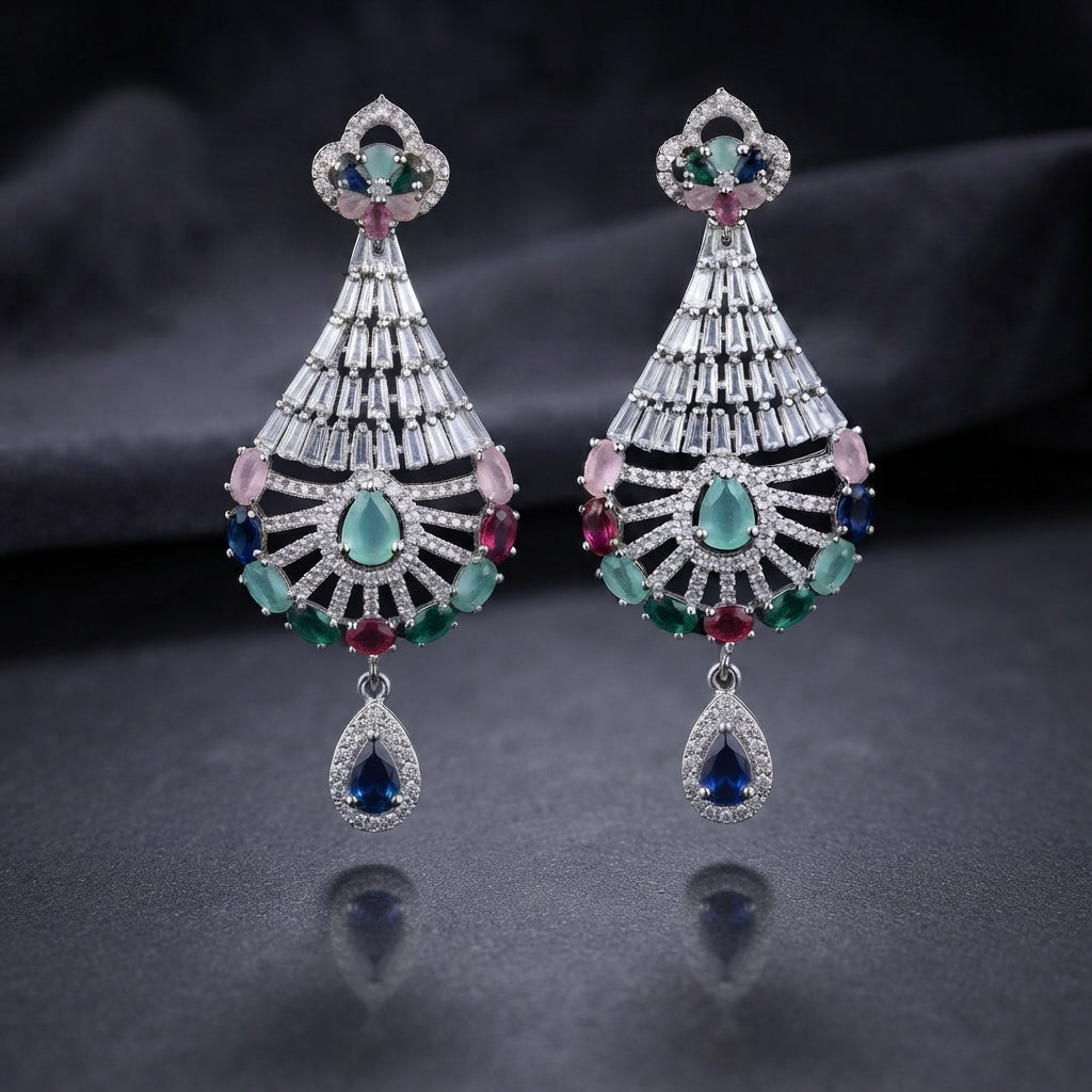 CZ Baguette Fan and Multicolour Sunburst Peacock Drop Earrings in Silver Multicolour worn by model in cream outfit with ornate backdrop close-up detail showing rhodium silver baguette cone fan peacock spoke fan with multicolour oval CZ accents and sapphire blue pear halo drop