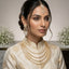 CZ Bridal Multi-Layer Drape Necklace Set with Starburst Brooch in Gold model wear editorial showing South Asian bride wearing 4-strand draped CZ necklace with starburst shoulder brooch matching starburst tassel earrings and maang tikka with champagne gold finish on cream bridal outfit