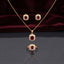 CZ Cushion Halo Pendant Necklace Stud Earrings and Ring Set in Ruby Red CZ gold-tone flat lay on burgundy wine velvet backdrop showing 3-piece set with deep ruby red cushion CZ center in white CZ micro-pavé halo gold-tone pendant necklace matching stud earrings and cocktail ring with mirror reflection