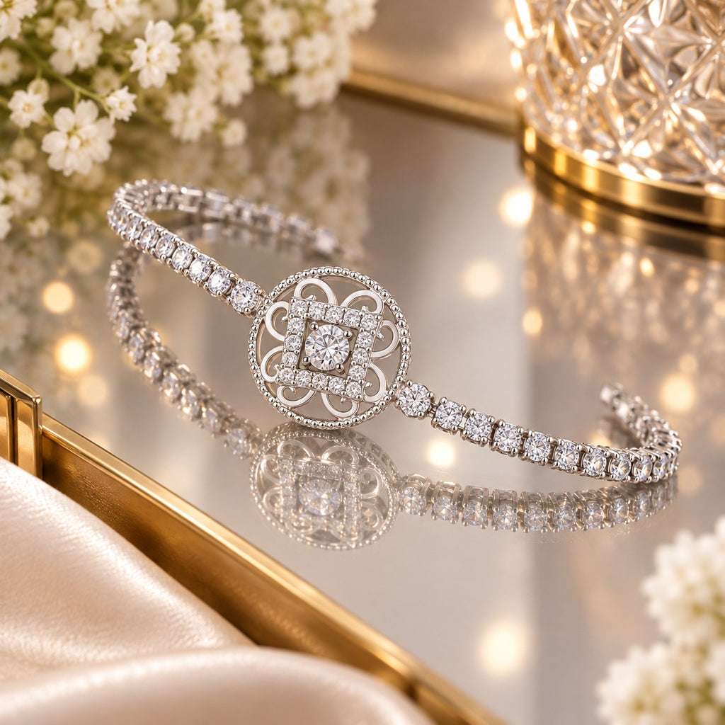 CZ Filigree Arabesque Medallion Centrepiece Round CZ Tennis Chain Bracelet in silver-tone flat lay on mirror surface with crystal candleholder, white flowers and cream silk fabric