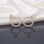 CZ Marquise Circle Drop Earrings with Pave Disc Top in Gold pair lying side by side on dark mirror surface with white satin fabric backdrop showing 18K champagne gold-tone fully pave CZ open-circle disc stud top suspending large open circle drop fully encrusted with radial marquise CZ in crown sunburst arrangement with mirror reflection below