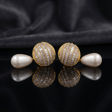 Gold-Tone Baguette CZ Globe Sphere Stud & Pearl Teardrop Drop Earrings on black mirror surface with dark grey silk fabric backdrop