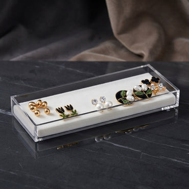 Gold Black Floral Enamel Pearl CZ 4-Pair Stud Earring Set flat lay on black marble surface with grey fabric backdrop showing gold double ball studs black tulip enamel studs with green leaf white CZ pearl drop studs and large black round enamel hoop with pearl leaf cluster black clover and CZ starburst stud with mirror reflections