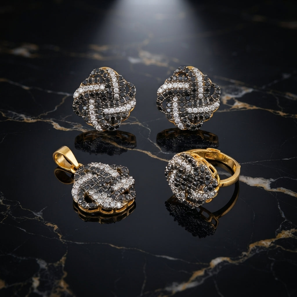 Gold-Tone Black & White CZ Quatrefoil Clover 3-Piece Jewelry Set — pendant, earrings and ring on black marble surface