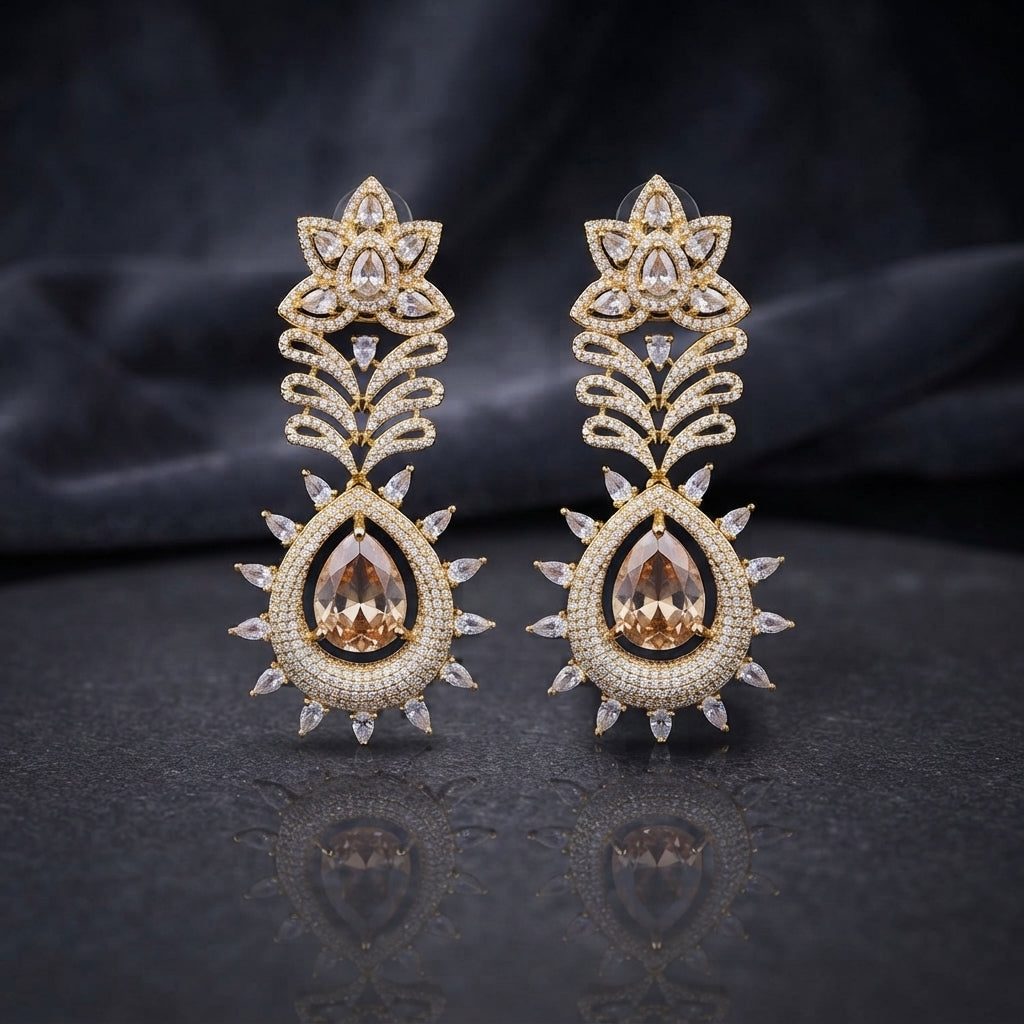 Gold Champagne CZ Lotus Crown and Pear Halo Sunburst Marquise Drop Earrings on dark mirror surface with charcoal backdrop showing 22K warm gold-tone grand drop earring pair with large lotus crown marquise white CZ petals open feather palm frond micro-pave champagne CZ connector and grand champagne morganite pear CZ halo pendant with double-row halo and outer marquise white CZ sunburst fringe
