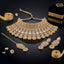 Gold-Tone Champagne CZ Polki Pear & Square Kundan Wide Tiered Scalloped Bib Choker Necklace Drop Earrings & Maang Tikka 3-Piece Bridal Set on black mirror surface with loose champagne CZ stones, gold ribbon and navy blue velvet jewelry box backdrop