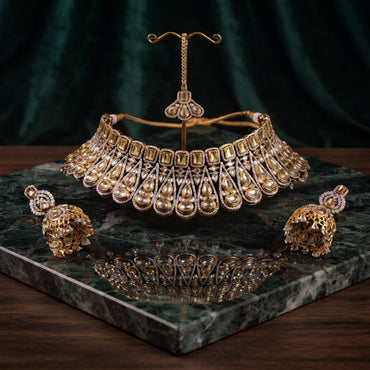 22K Gold-Tone Champagne Emerald-Cut CZ & Pear Polki Kundan Tiered Scalloped Bib Choker Necklace Gold Filigree Sphere Jhumka Earrings & Maang Tikka 3-Piece Bridal Set on green marble tray with dark green velvet drape backdrop