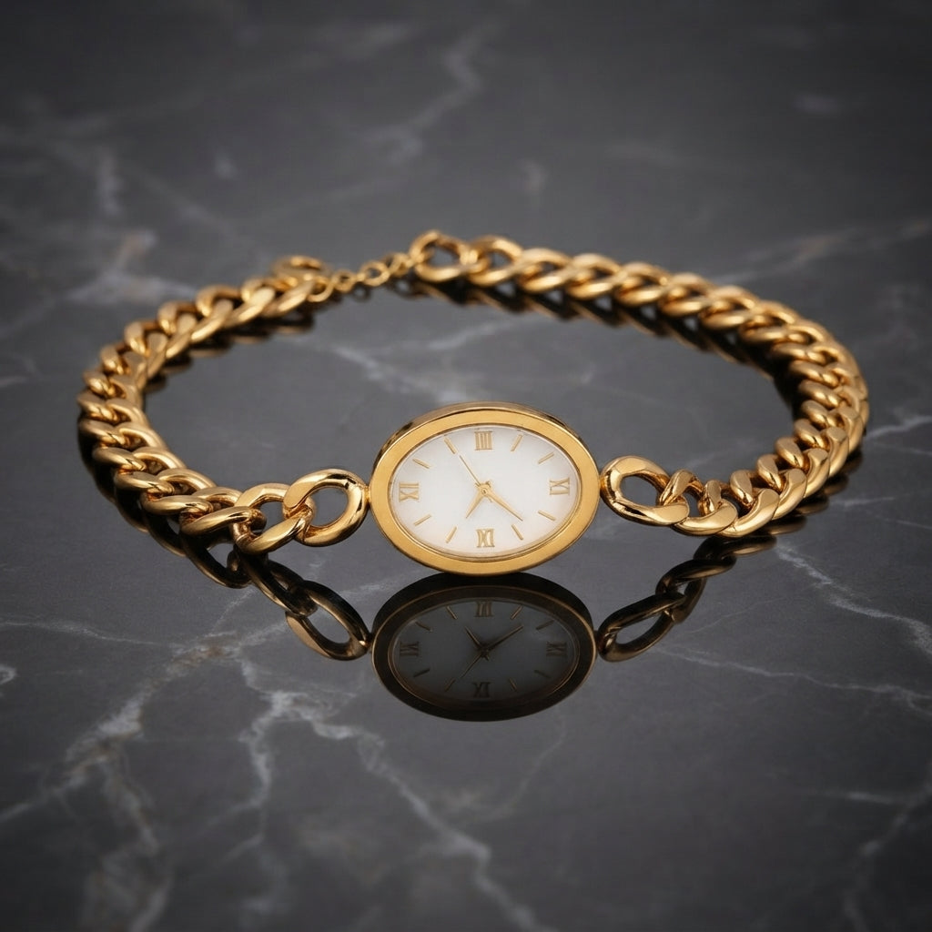 Gold Cuban Link Chain Oval Bracelet Watch in 18K gold-tone PVD stainless steel on dark grey marble surface showing bold Cuban curb link chain bracelet with smooth oval landscape gold-tone watch case and decorative white Roman numeral watch-face dial sticker with slim gold-tone hands and mirror reflection below