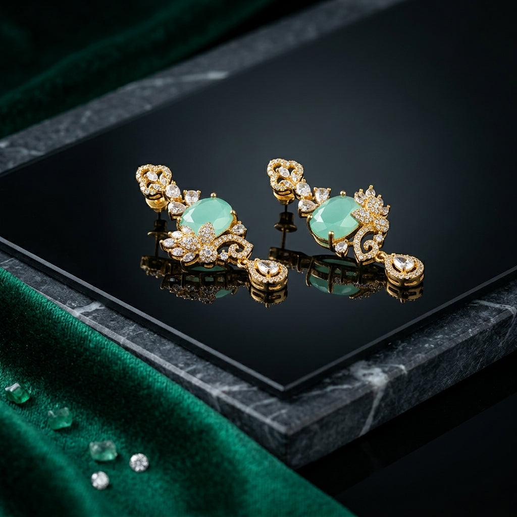 Gold-Tone Cushion Cut CZ Baroque Arabesque Filigree Butterfly Pavé & Pear Drop Chandelier Stud Earrings in Mint Jade Green on black mirror surface with green marble and emerald green velvet fabric backdrop