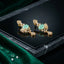 Gold-Tone Cushion Cut CZ Baroque Arabesque Filigree Butterfly Pavé & Pear Drop Chandelier Stud Earrings in Mint Jade Green on black mirror surface with green marble and emerald green velvet fabric backdrop