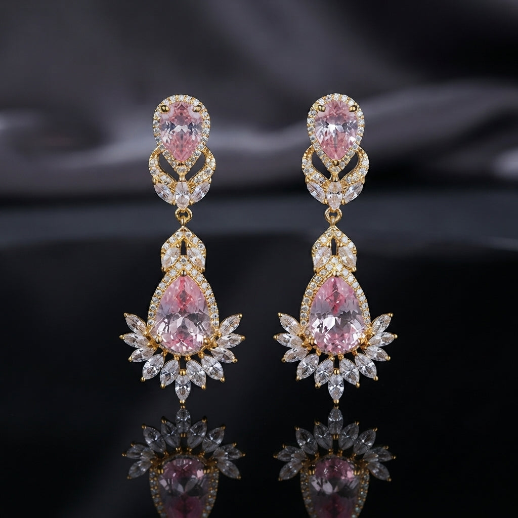 Gold CZ Double Teardrop Marquise Fan Chandelier Earrings in Crystal Clear pair on dark mirror surface with grey silk backdrop showing 18K gold-tone small crystal clear pear CZ stud with white CZ pave halo infinity connector and large crystal clear pear CZ drop with white CZ pave halo and marquise CZ fan crown with mirror reflection below