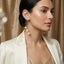 Gold-Tone CZ Ear Crawler Cuff & Triple Pearl Drop Chain Tassel Earrings worn on South Asian female model in ivory embroidered blazer with gold drape curtain backdrop