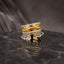 Gold CZ Eternity Twist Band Teardrop Charm 4-Piece Stackable Ring Set side angle view on black marble surface with grey silk backdrop showing layered stack detail of micro-pave CZ eternity bands matte brushed twist band and teardrop CZ briolette charm drops with mirror reflection below