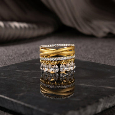 Gold CZ Eternity Twist Band Teardrop Charm 4-Piece Stackable Ring Set front view on black marble surface with grey silk backdrop showing four stacked rings including two micro-pave white CZ eternity bands matte brushed gold criss-cross twist wide band and gold ball bead band with five dangling pear teardrop white CZ briolette drops with mirror reflection below