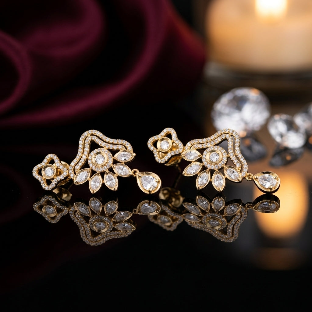 Gold-Tone CZ Pavé Fan & Marquise Leaf Chandelier Drop Earrings product shot on black reflective surface with rose and candle backdrop