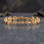 22K Gold-Tone CZ Filigree Heart Link Chain Bracelet on grey stone surface with pyrite mineral crystals and dark charcoal geometric backdrop