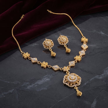 Gold CZ Filigree Sunburst Pendant Necklace and Drop Earrings Set with Diamond Station Chain — 22K antique gold-tone 2-piece set with alternating diamond rhombus CZ station chain with butterfly connectors large open filigree sunburst disc pendant with CZ daisy center and gold cone drop and matching round filigree cone drop earrings displayed on dark slate marble surface with crimson velvet backdrop and mirror reflection