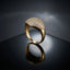 Gold CZ Micro-Pavé Cushion Dome Signet Cocktail Ring — 22K gold-tone modern luxury signet ring with large cushion oval dome fully covered in dense round white CZ micro-pavé, smooth seamless transition to high-polish tapered gold shank, on dark grey mirror surface with luxury editorial backdrop