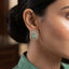 Gold CZ Open Filigree Rectangle Frame and Solitaire Stud Earrings in Mint Green on dark mirror surface with charcoal satin backdrop showing 22K gold-tone open rectangular filigree frame with micro-pave CZ border large round white CZ bezel solitaires and soft mint green emerald-cut CZ centre stone