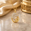 22K Gold-Tone CZ Pavé Wave & Puffy Swirl Pendant Necklace on cream marble surface with champagne gold satin fabric and Mughal gold decorative box backdrop