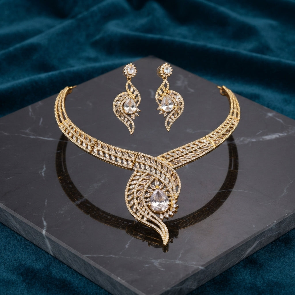 Gold CZ Peacock Feather Leaf Torque Necklace & Drop Earrings Set in White Crystal CZ on dark grey marble with teal velvet backdrop