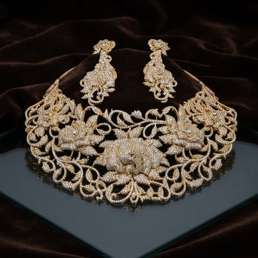 Gold CZ All-Gold Rose Bloom Openwork Floral Bib Choker & Drop Earrings Grand Bridal Set on dark grey mirror surface with dark brown velvet drape backdrop